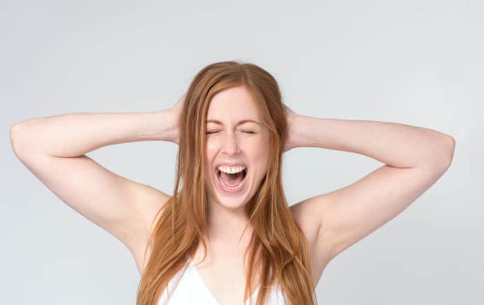 shouting woman hands on head