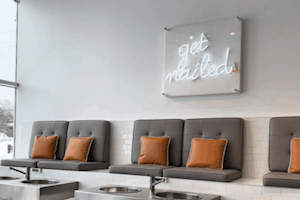 pedicure seats with a neon-led sign above stating 'get nailed'